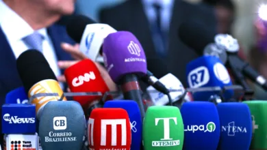 Profissional de imprensa trabalhando sob pressão diante de computador.
