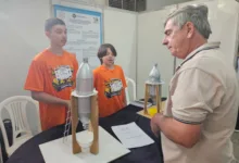 Estudantes segurando protótipo de silo feito com garrafa PET