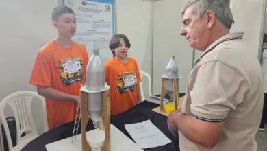 Estudantes segurando protótipo de silo feito com garrafa PET