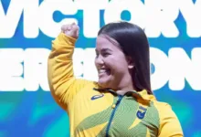 Atleta brasileira competindo em torneio de halterofilismo.
